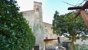 A courtyard with stone walls, a grassy area, and a table set for dining. - CASA VISTA - Four Bedroom Villa, Sleeps 8 (Gaiole in Chianti)