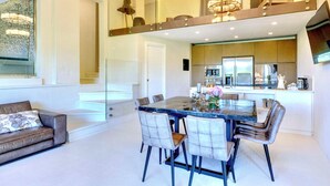 A modern kitchen with a dining area, a sofa, and a staircase. - VILLA CHIANTI ROSSO - Four Bedroom Villa, Sleeps 9 (Greve in Chianti)