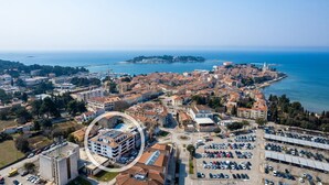 An aerial view of a coastal town with historic buildings, a marina, and a large parking area. - Apartment Val di Sole II (Porec)