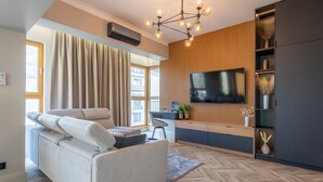Un salon moderne avec un canapé, un téléviseur et un panneau mural en bois.