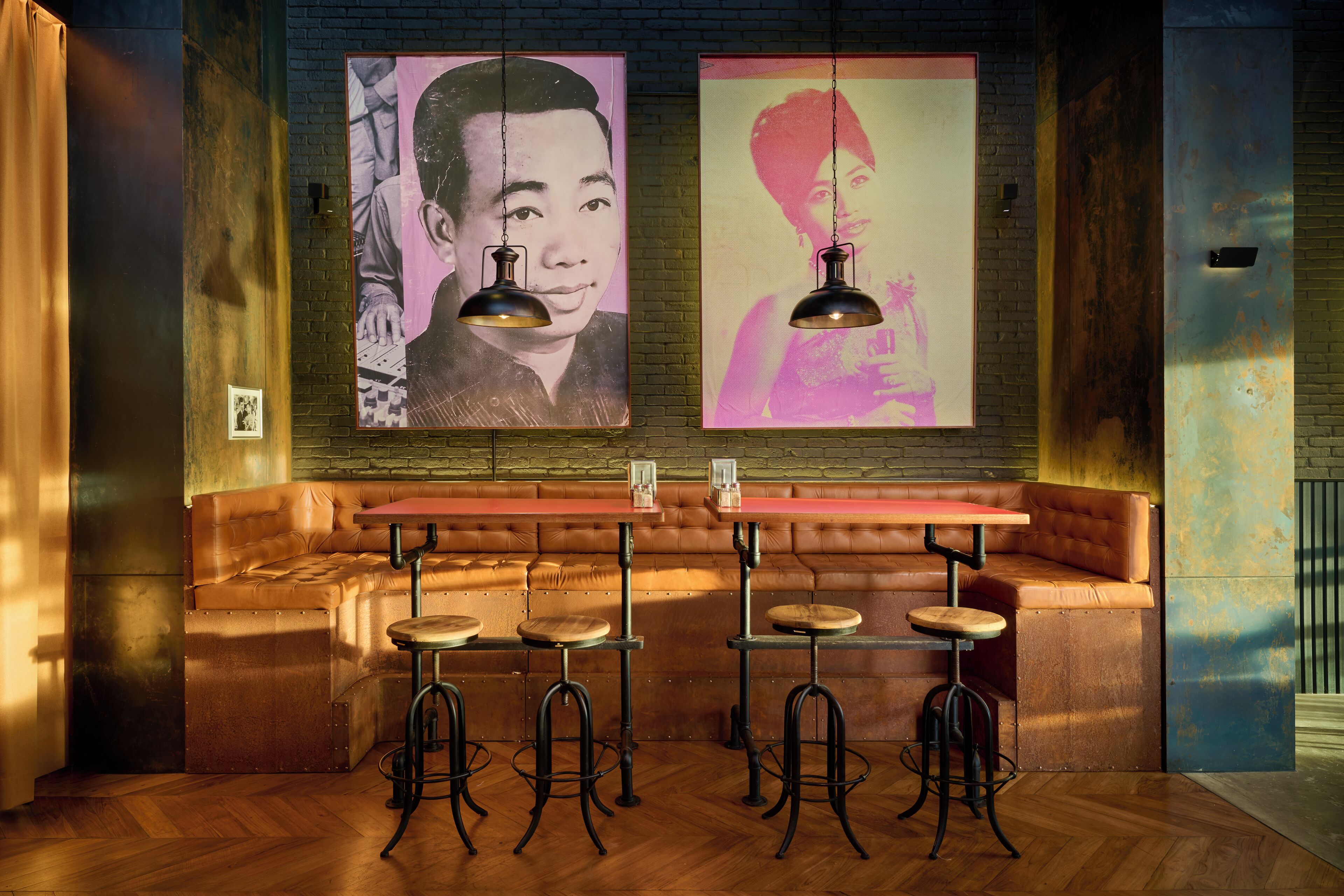 A bar area with a wooden bench, stools, and two hanging pendant lights.