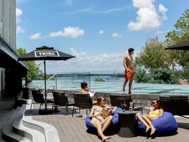 Una piscina al aire libre, sombrillas, sillones reclinables de piscina