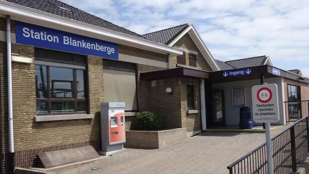 En tågstation som heter ”Station Blankenberge”, med en biljettautomat och en skylt som visar ”Ingång”.