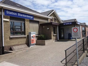 A train station named 'Station Blankenberge' with a ticket machine and a sign indicating 'Ingang' for entry.
