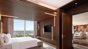 Une chambre d’hôtel moderne dotée d’un grand lit, d’une télévision, d’un coin salon et offrant une vue sur la ville.