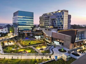 A modern building complex with multiple floors, a landscaped courtyard, and a parking area. - Mercure Pangkalan BUN (Pangkalan Bun)