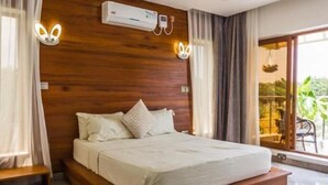 A modern bedroom with a wooden headboard, a large bed with white bedding, and a built-in bench at the foot of the bed. - Stay.Plus Diani Luxurious Villa (Diani Beach)