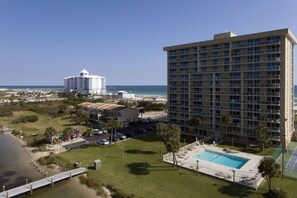 Un hotel con piscina, vista al mar y estacionamiento.