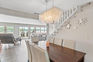 Stunning living area with a high ceiling, staircase, and decorative elements, including a turtle and octopus sculpture.
