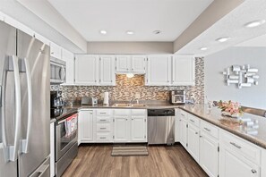 Enjoy cooking in this well-equipped kitchen with oven, microwave, and dishwasher, plus ample counter space for food preparation.