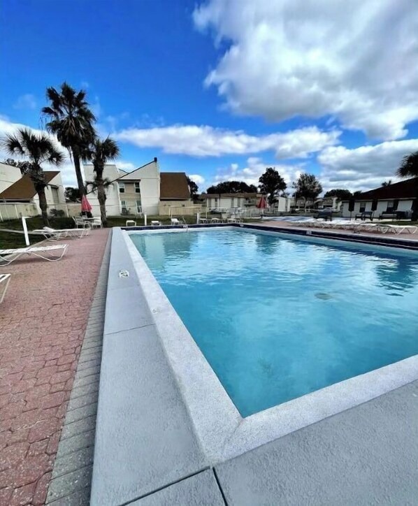 Relax by the pool surrounded by lush palm trees and scenic views.