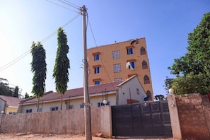 A multi-story building with a red-tiled roof, a gated entrance, and a sign reading "THE TERRACE".
