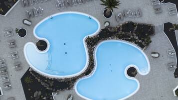 4 buitenzwembaden, ligstoelen bij het zwembad