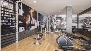 A gym with exercise equipment, wooden flooring, and a large mirror. - MYND Yaiza (Yaiza)