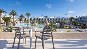 A resort with a pool, lounge chairs, and palm trees. - MYND Yaiza (Yaiza)