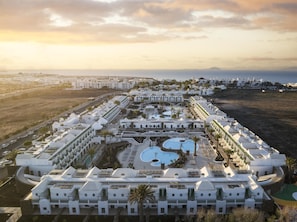 A resort with multiple buildings, a central pool area, and a view of the sea. - MYND Yaiza (Yaiza)