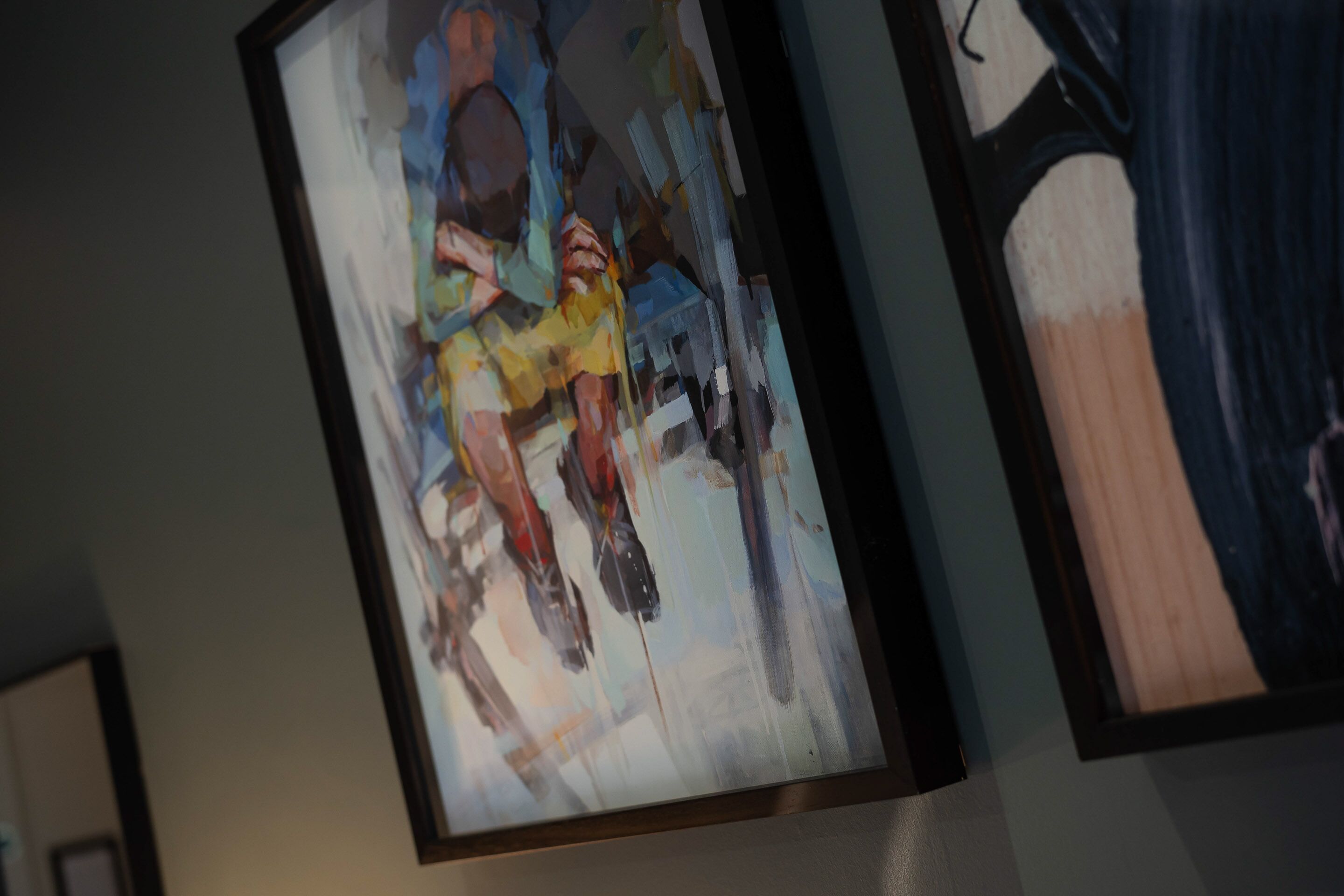 A framed abstract painting with a mix of colors and shapes.