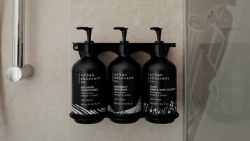 Three black bottles of Urban Skincare Co. products on a wall.