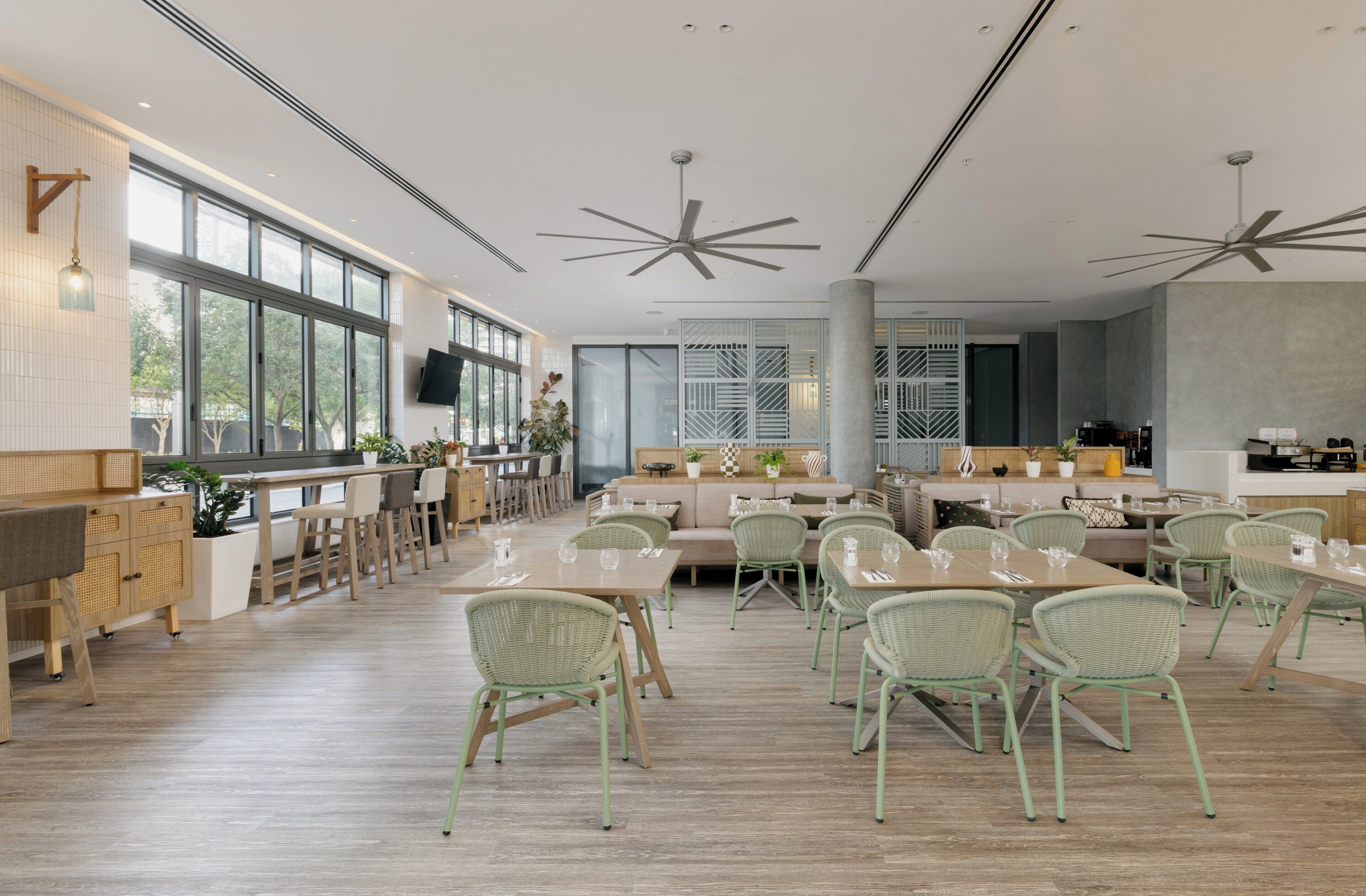 Un vaste espace dédié à la salle à manger, doté de hauts plafonds, de grandes fenêtres et de mobilier moderne.