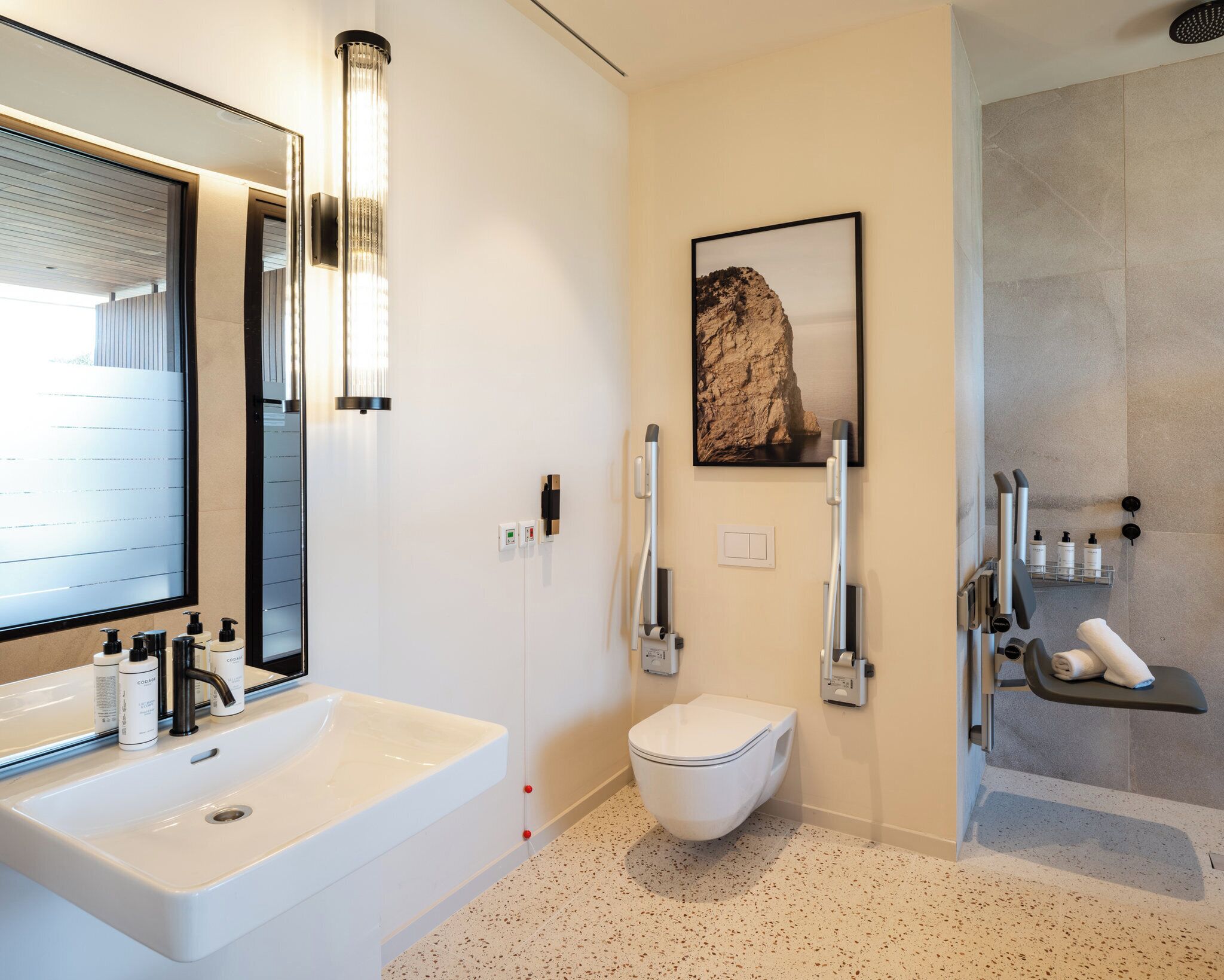 Un baño moderno con un lavamanos grande, un espejo y una zona de ducha.