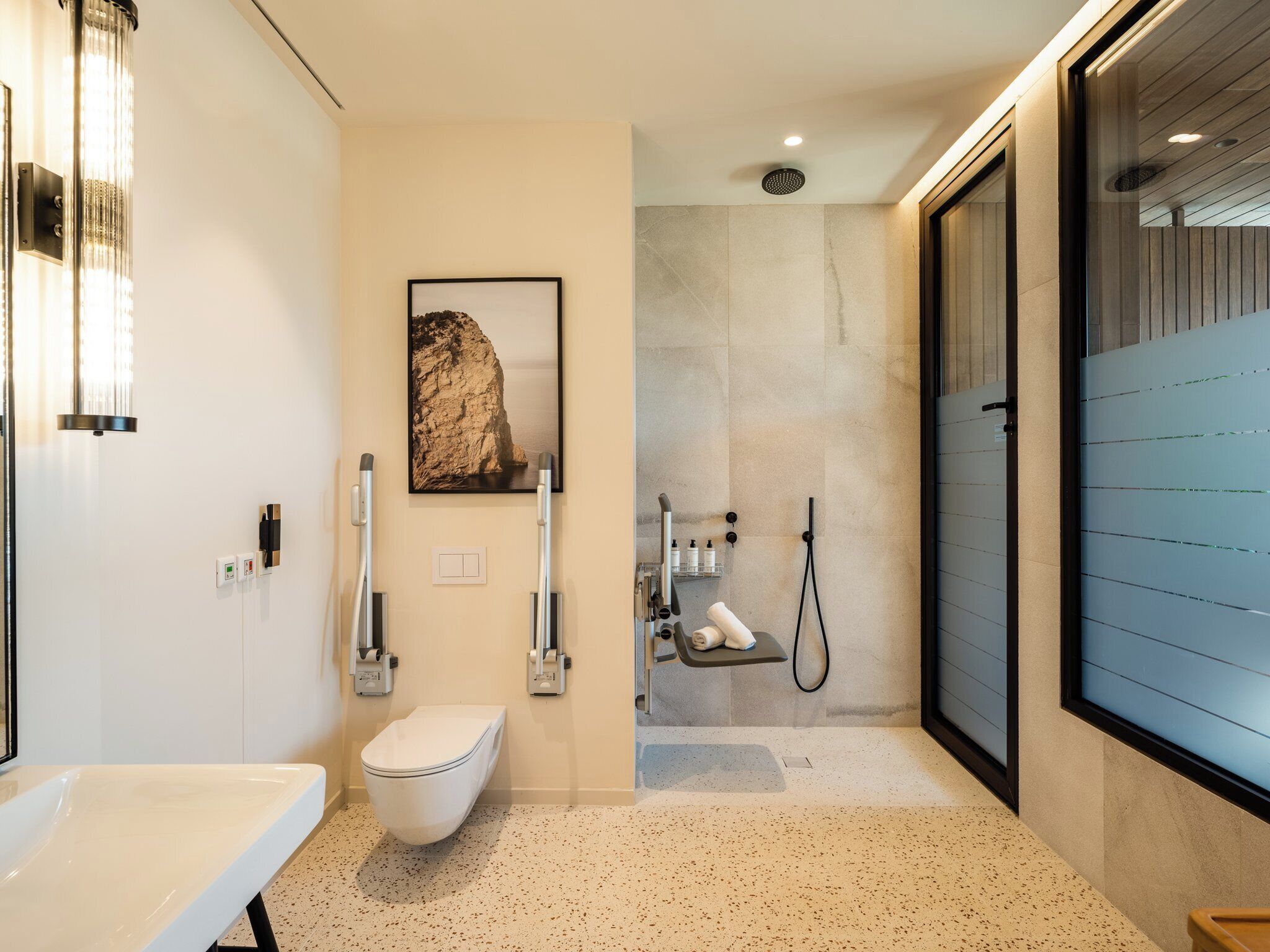 A modern bathroom with a toilet, bidet, and shower area.