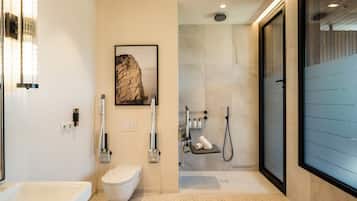 A modern bathroom with a toilet, bidet, and shower area.