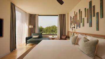 Ein Hotelzimmer mit einem großen Bett, einer Couch, einem kleinen Tisch und einem Deckenventilator.