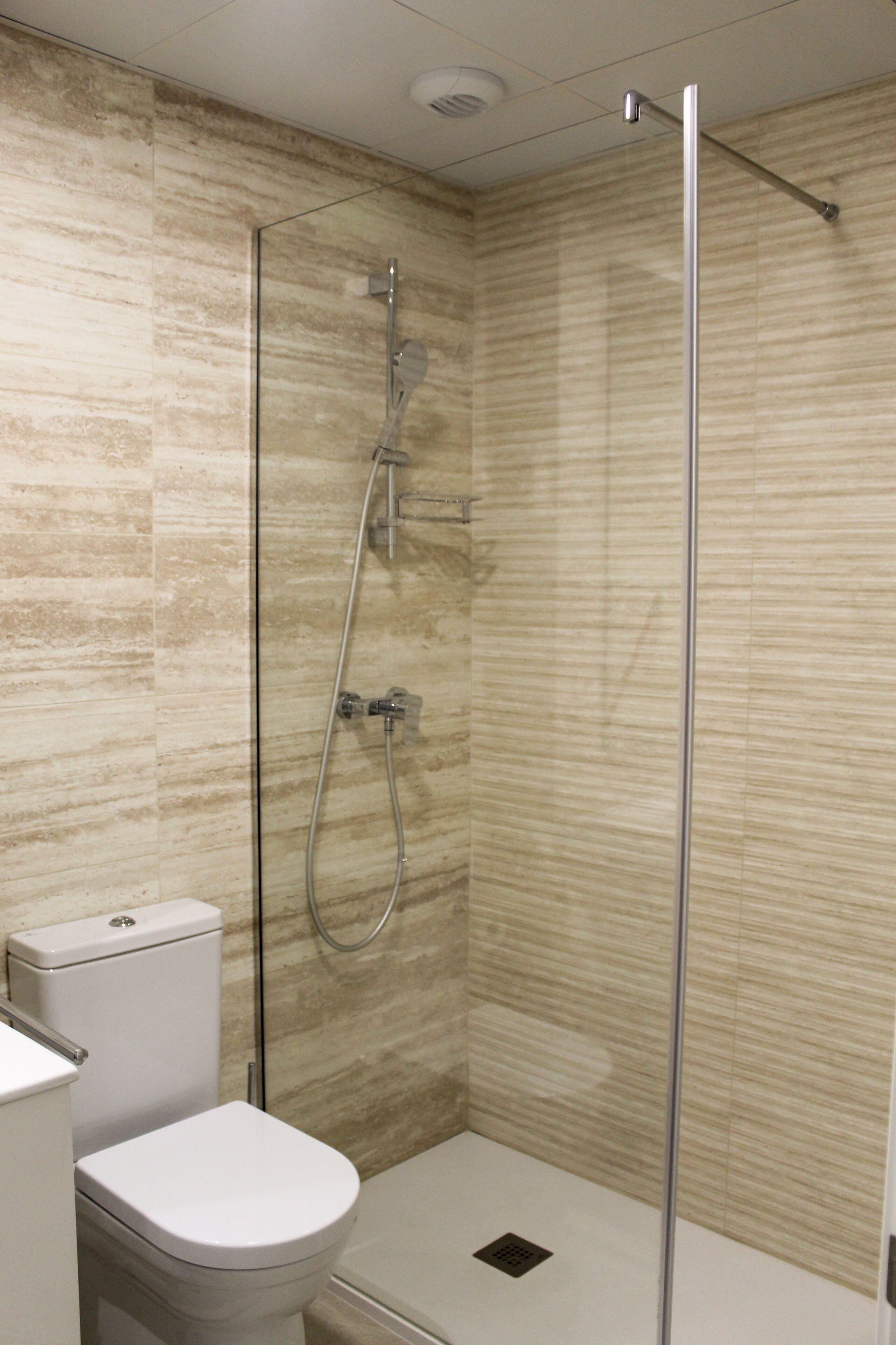 A bathroom with a shower, toilet, and sink.