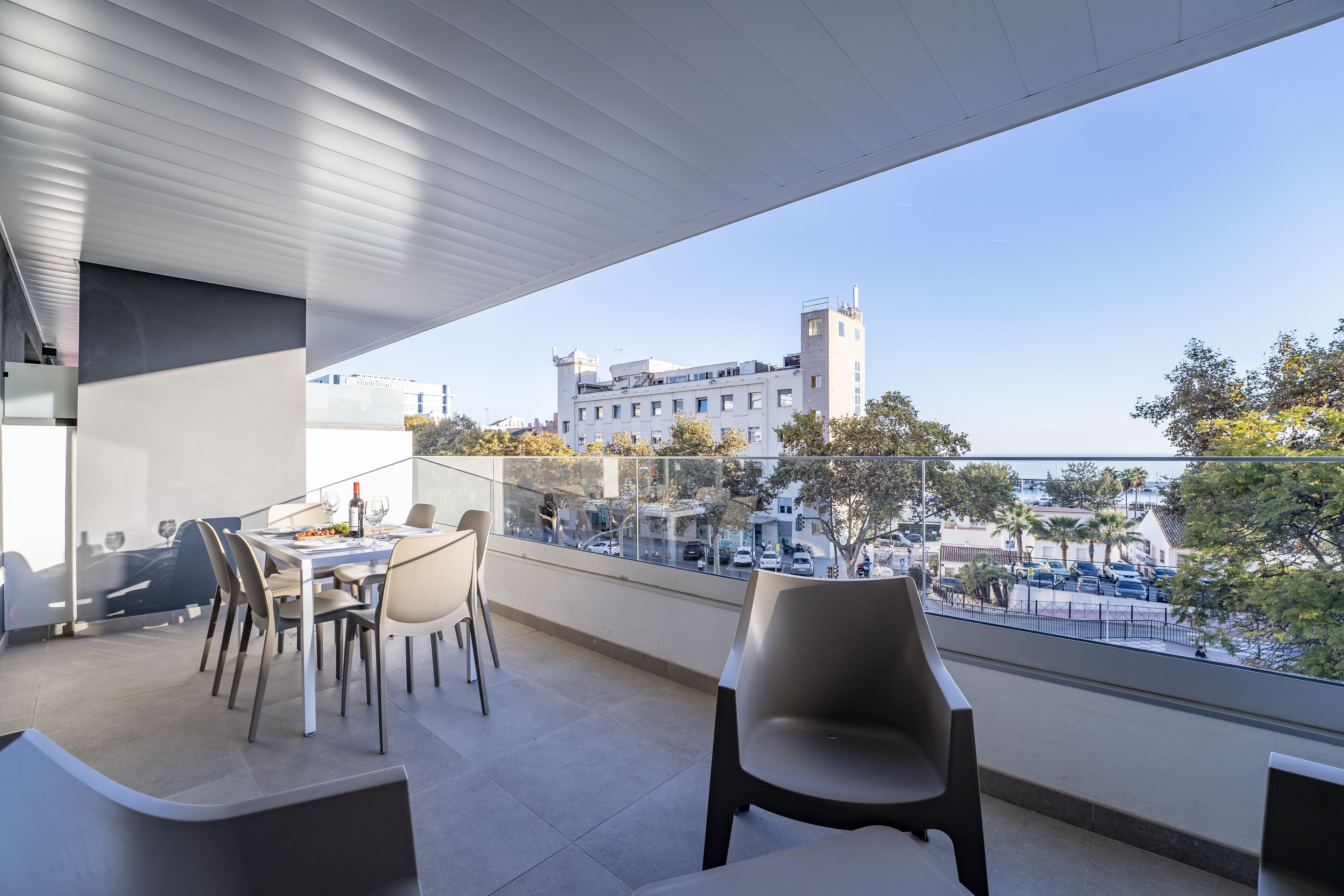 Un espace de restauration extérieur moderne offrant une vue sur le paysage urbain et un bâtiment doté d’une tour.