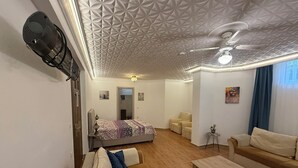 A modern living room with a sofa, a coffee table, and a bed with a patterned blanket. - Arslan Villa (Marmaris)