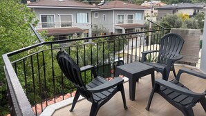 A balcony with outdoor furniture, a view of residential buildings, and a hilly landscape in the background. - Arslan Villa (Marmaris)