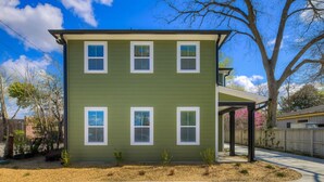 A two-story house with a green exterior and white trim. There is a covered porch on the right side. - Green House @ Township - Unit B | 3BR 3BA (Columbia)