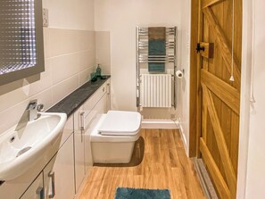 A small bathroom with a sink, toilet, and towel rack.