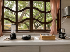 Una cocina con licuadora, cafetera y una caja de madera en la encimera.