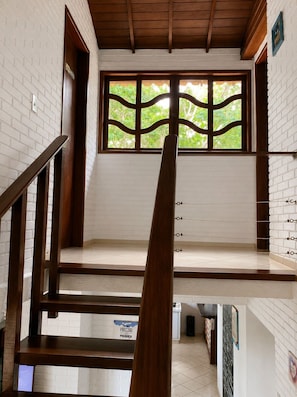 Una escalera con barandillas de madera que conduce a una plataforma con vistas a zonas verdes.