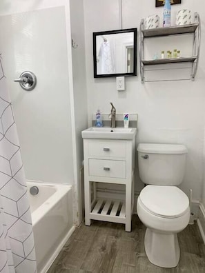 Bathtub, hair dryer, towels, shampoo
