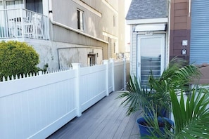 A residential building with a white fence, a potted plant, and a garage door marked with the number 405.
