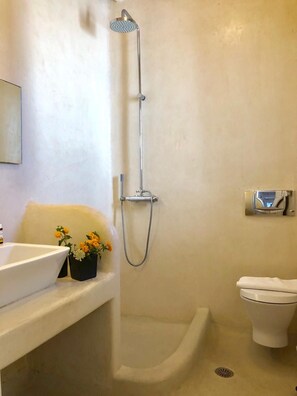 Un baño con ducha, inodoro y lavamanos con flores.