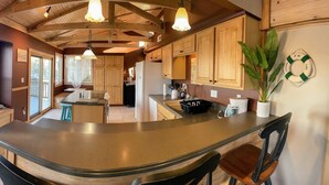 Una cocina con armarios de madera, una isla central e iluminación colgante.