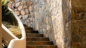 A stone staircase with a beige wall and a plant on the left. - Villas Coral Huatulco (Santa María Huatulco)