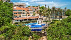 A resort with multiple buildings, a swimming pool, and lush greenery. - Villas Coral Huatulco (Santa María Huatulco)