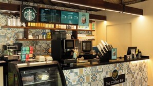 A coffee bar with a patterned backsplash, a display case with pastries, and a menu board above the counter. - Villas Coral Huatulco (Santa María Huatulco)