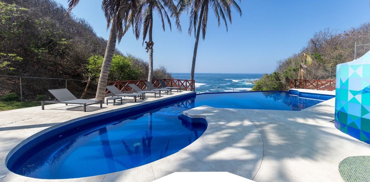 view of the pool and beach at Villas Coral Huatulco Resort