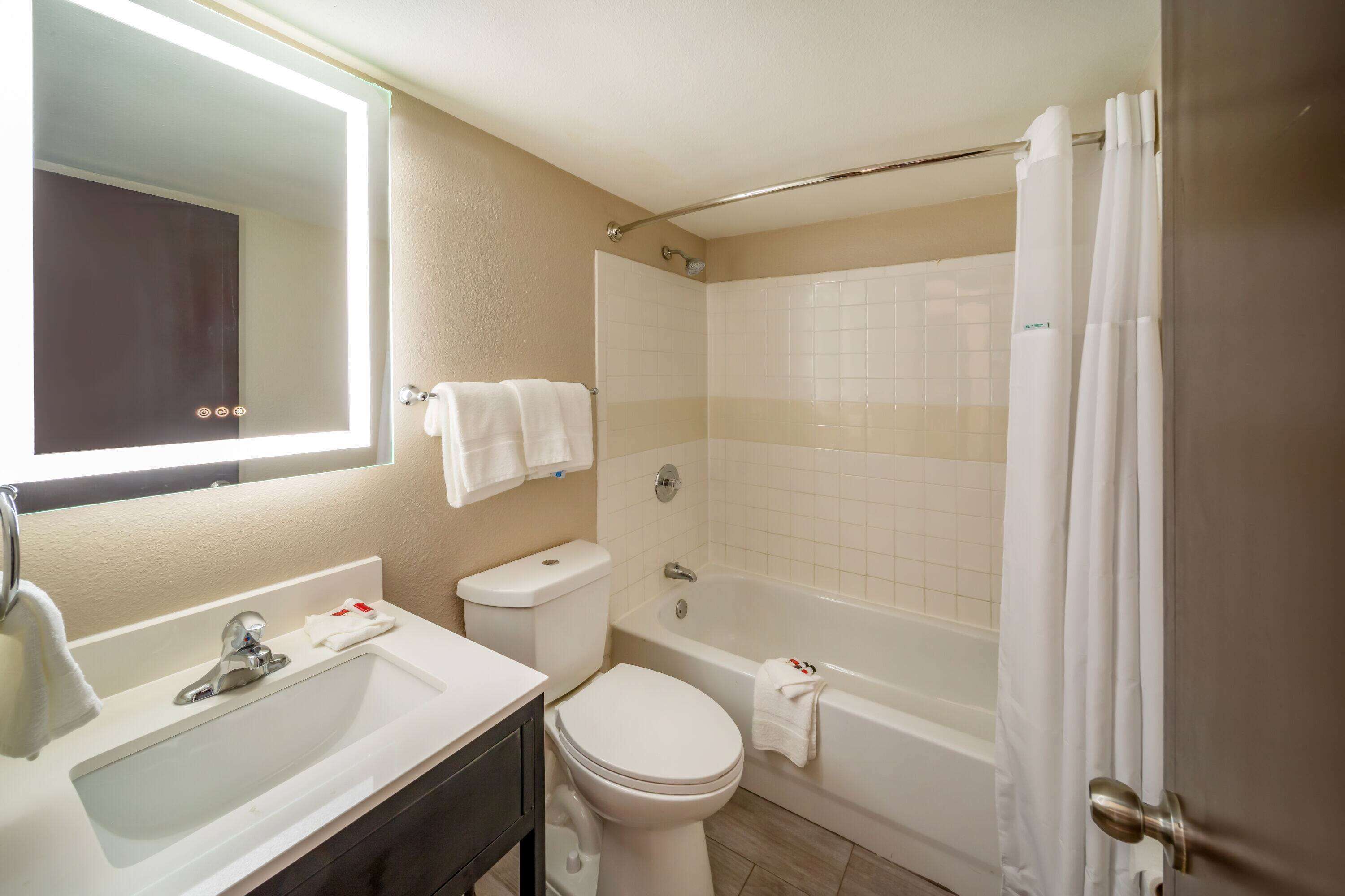 A bathroom with a sink, toilet, and bathtub.