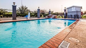 A swimming pool with a wooden deck, a waterfall feature, and a 'No Diving' sign. - Baymont by Wyndham Laredo (Laredo)