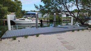 A marina with a dock, a boat, and a building in the background. - Gorgeous 3/2 SFH brand-new pool & spa,30ft dockage (Marathon)