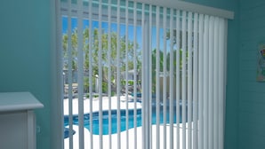 A room with a view of a swimming pool through white blinds. - Gorgeous 3/2 SFH brand-new pool & spa,30ft dockage (Marathon)