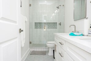 Enjoy a functional bathroom with a glass-enclosed shower, white toilet, and modern vanity.