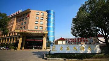 A hotel with a prominent entrance, a large blue cylindrical structure, and a sign with Chinese characters.
