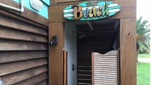 A wooden door with a sign that reads "Beach" above it. - Private Hot Tub with outdoor shower and tiki area to relax and Enjoy! (Galveston)